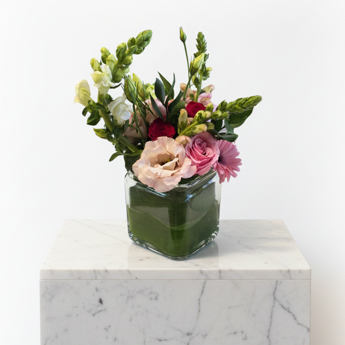 Ceramic Cupid’s Choice vase with a floral arrangement, featuring a decorative design and a clear glass vase for display.