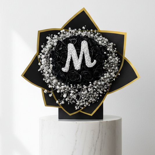 Black roses and silver baby's breath flower bouquet with a single letter card, arranged with elegant stems and greenery.