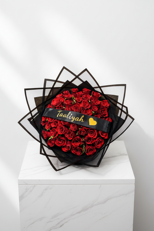 50 red roses with personalized ribbon from Jihaans Flower Emporium, arranged in a lush bouquet.