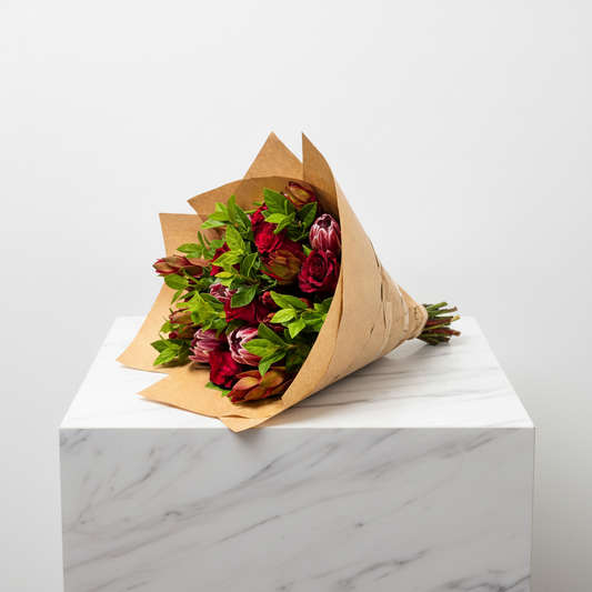 Colorful protea bunch featuring large, vibrant blooms and lush green foliage, perfect for floral arrangements.