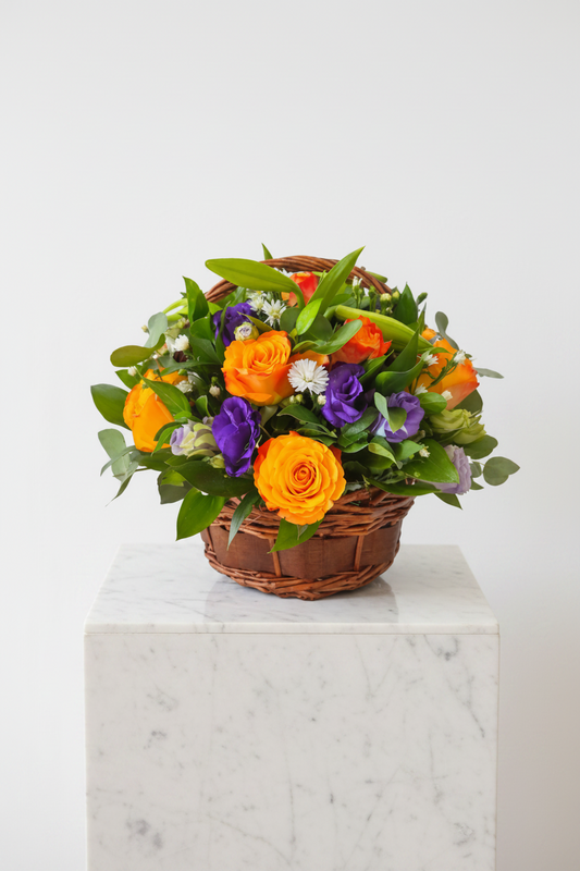 Dark wooden floral gift basket with fresh flowers and decorative accents, ideal for special occasions and celebrations.